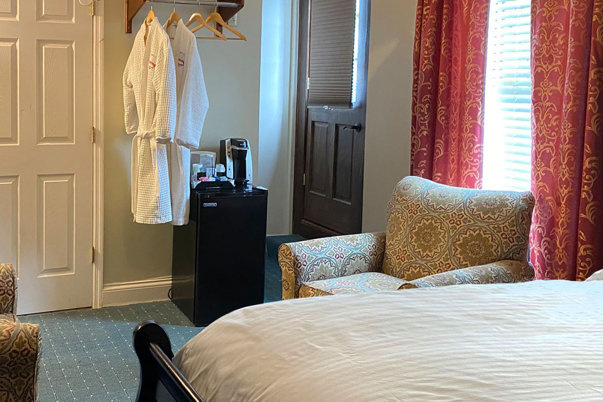 A suite with bed, chair and robes