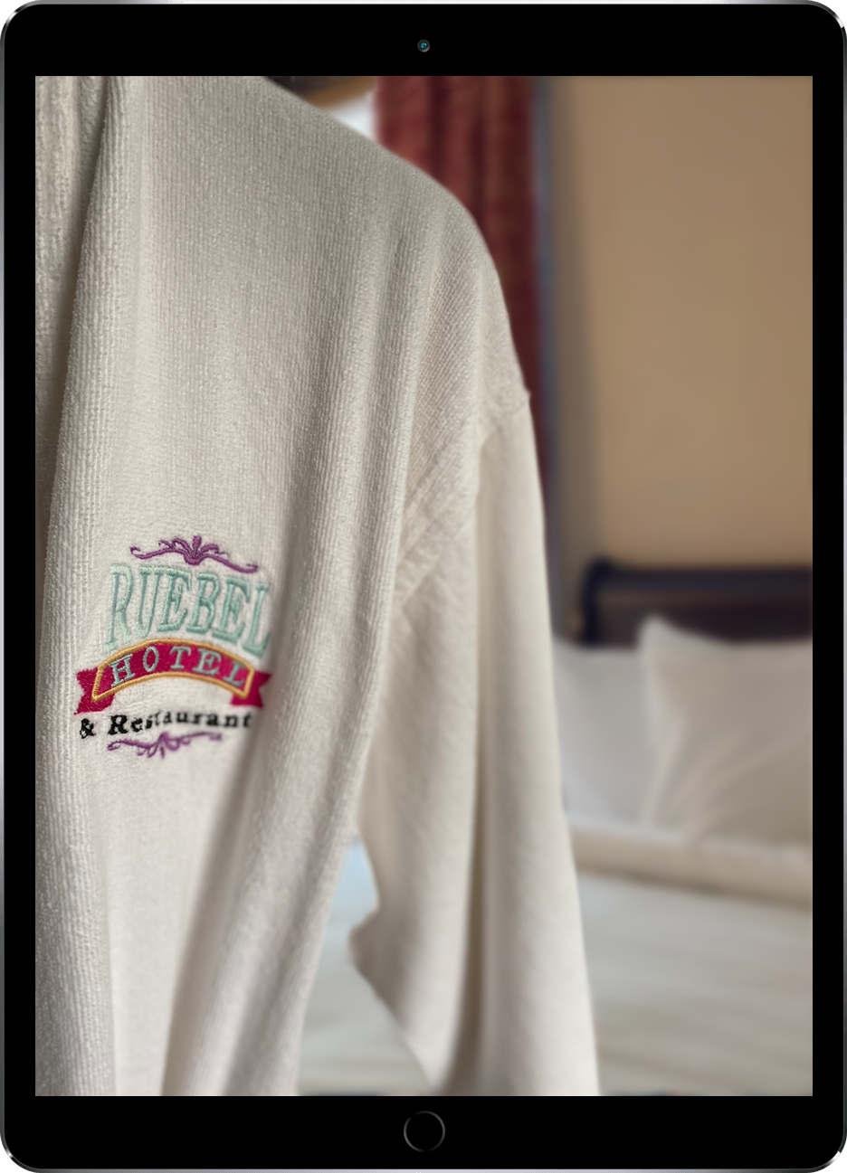 Ipad showing a photograph of a Ruebel Hotel Robe hanging in a room